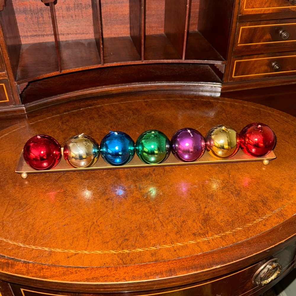 Holiday, gold platter with colored candles that look like Christmas balls